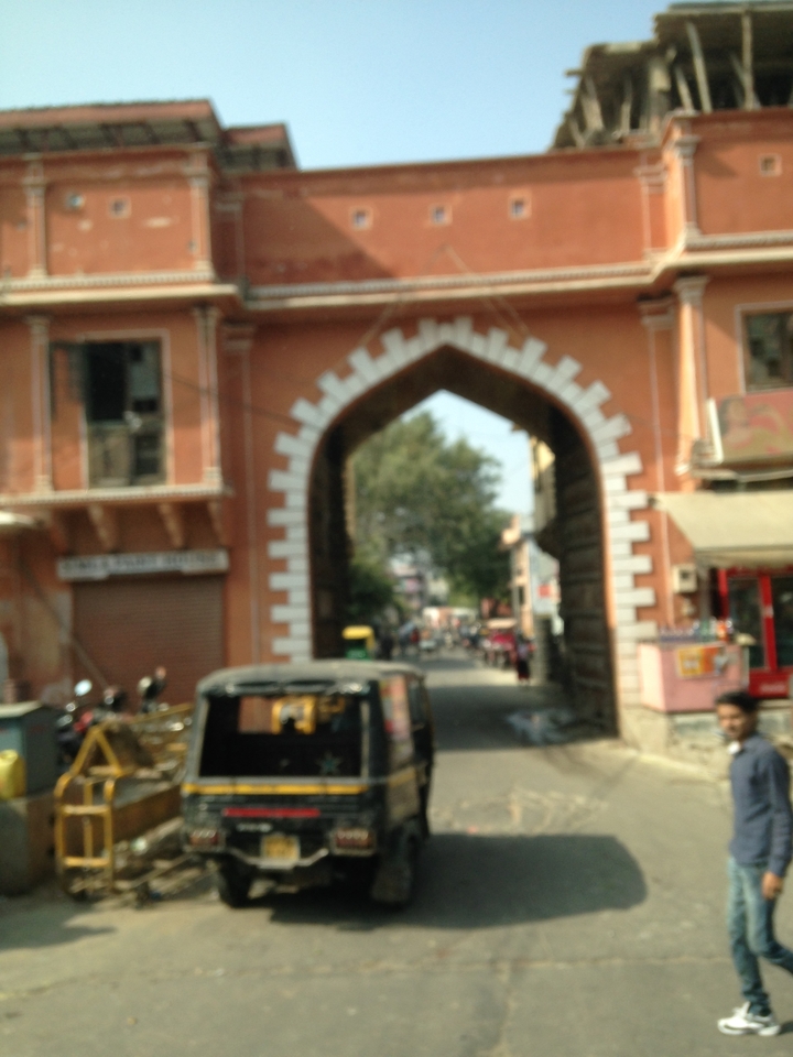 Image floue d'une arcade avec des véhicules et des personnes.