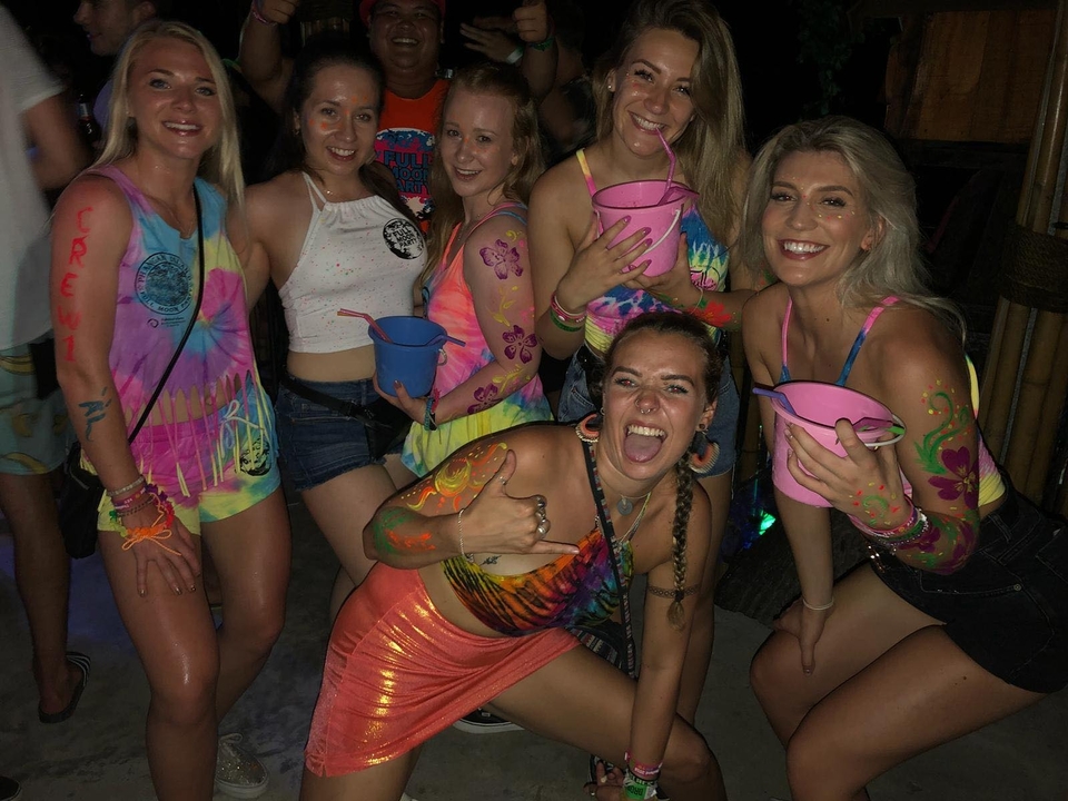 Groupe de personnes à une fête nocturne avec des tenues colorées.