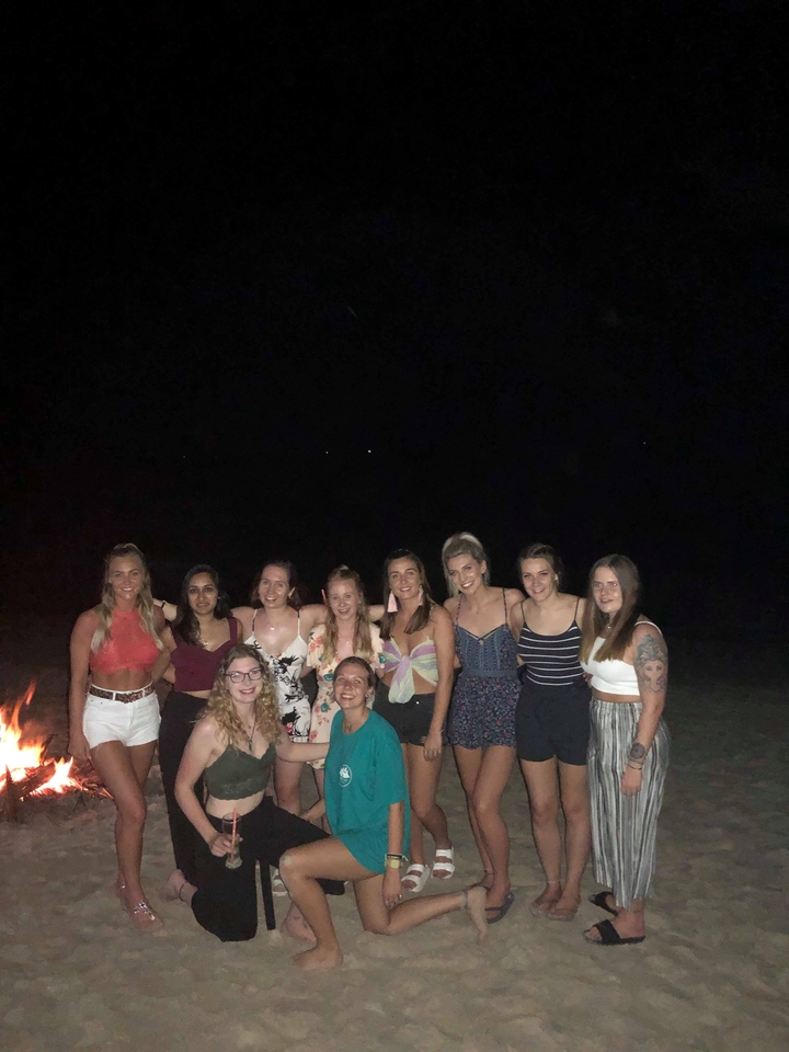 Group of women posing at night with a dark backdrop.