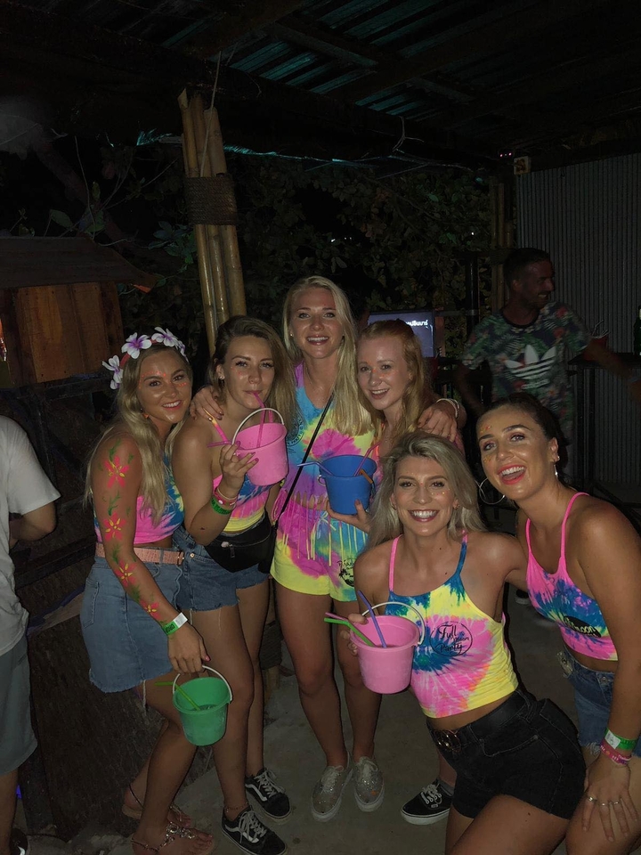 Groupe de personnes à une fête nocturne avec des vêtements colorés.