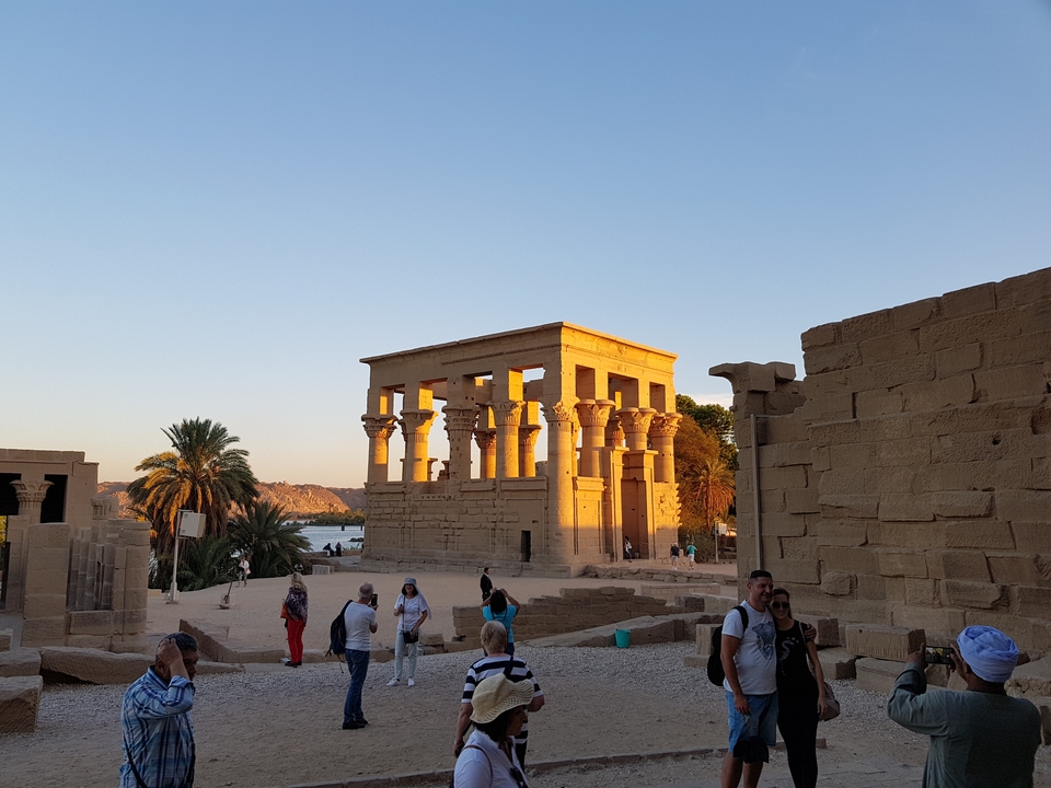 Temple historique avec des touristes dans la lumière du soir.