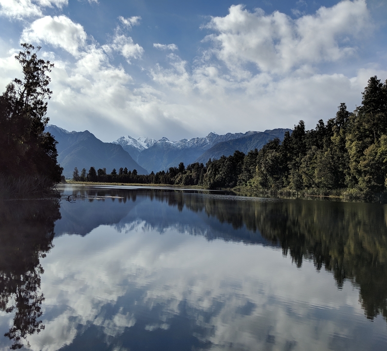 Reflective lake with mountains in the background.