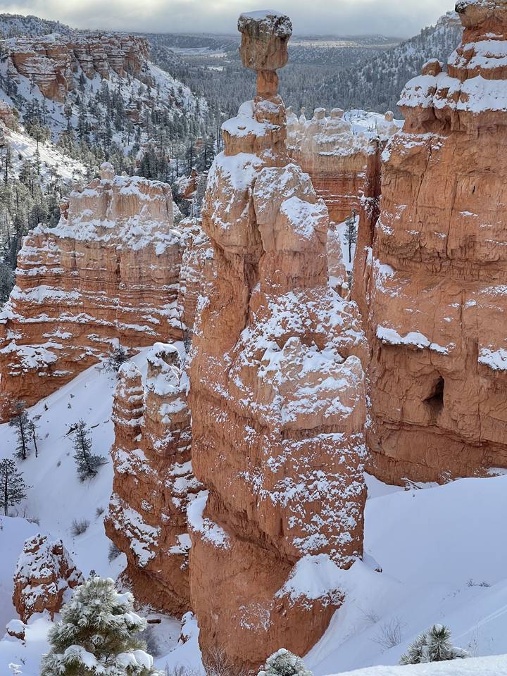 Des cheminées de fée saupoudrées de neige sur un décor hivernal.