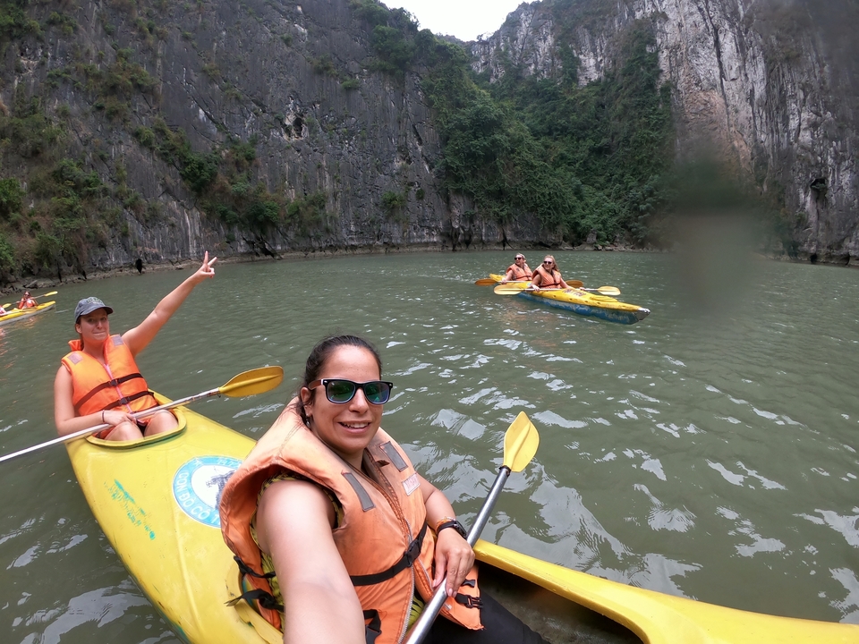Des gens qui font du kayak sur des eaux calmes entourées de hautes falaises.