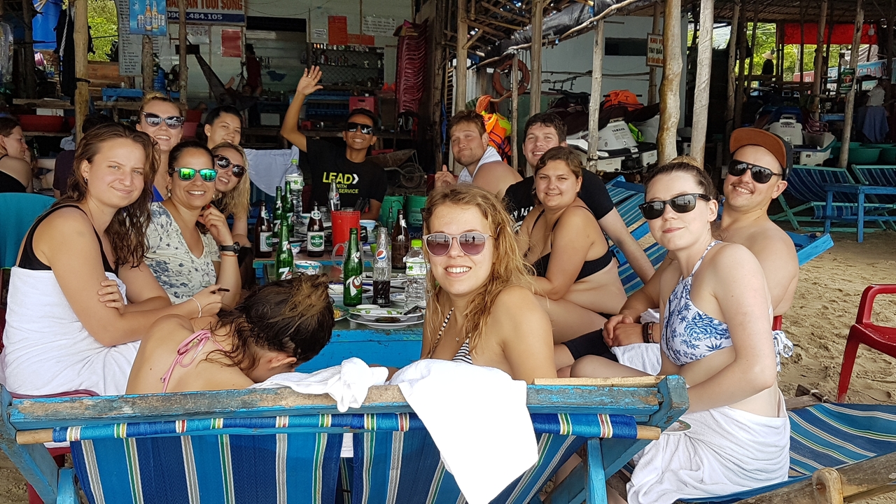 Groupe profitant de nourriture et de boissons dans un espace extérieur en bord de mer.