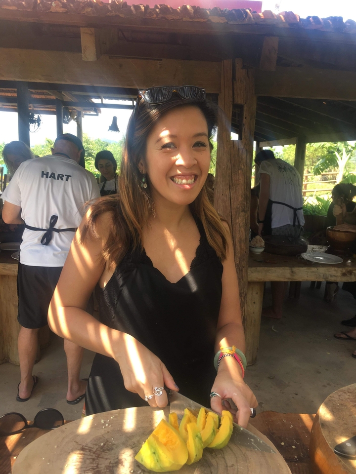 Femme souriante dans un cadre de cuisine en plein air.