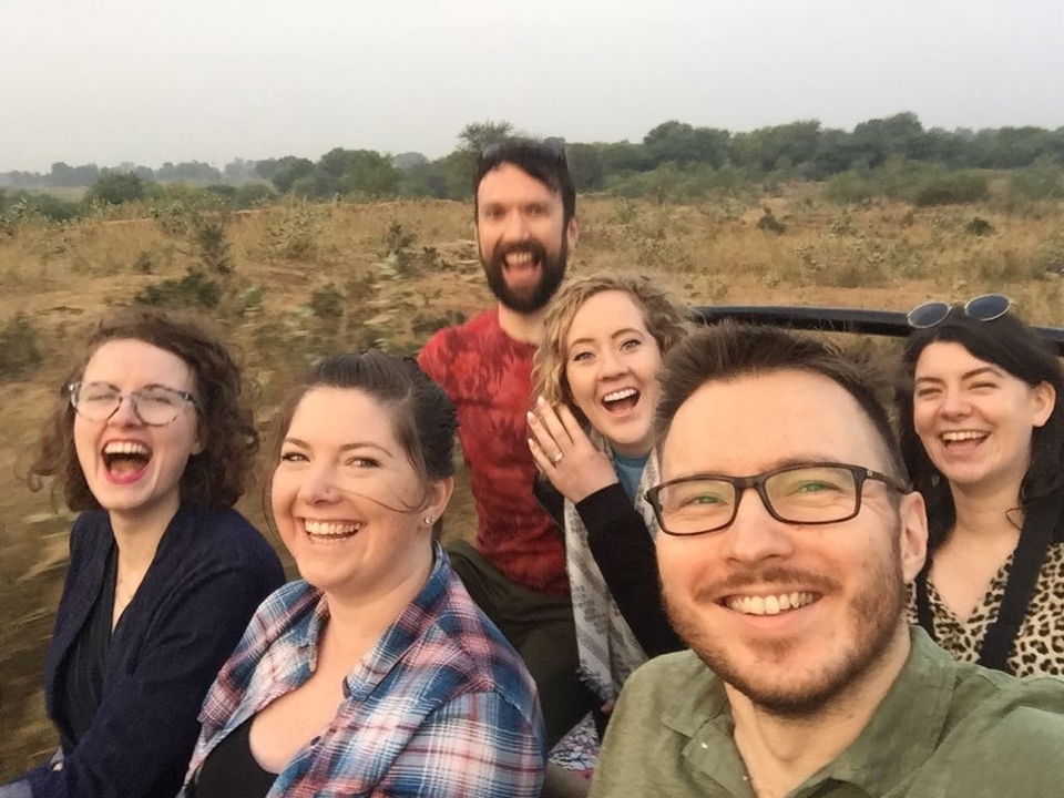 Un groupe de six personnes profitant d'un safari dans un véhicule ouvert.