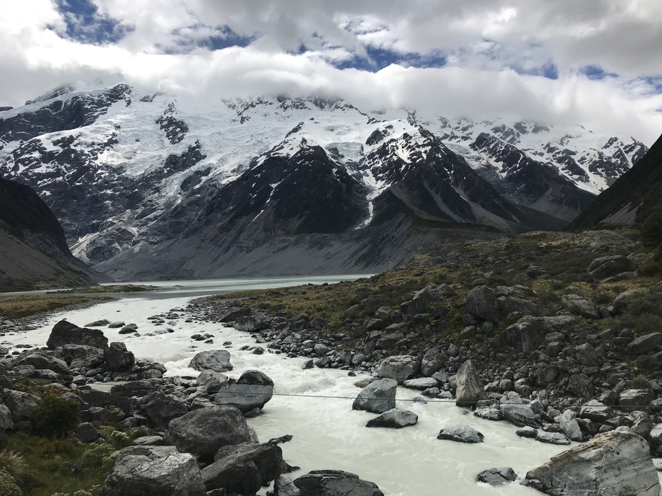 Des montagnes enneigées avec une rivière qui coule en contrebas.