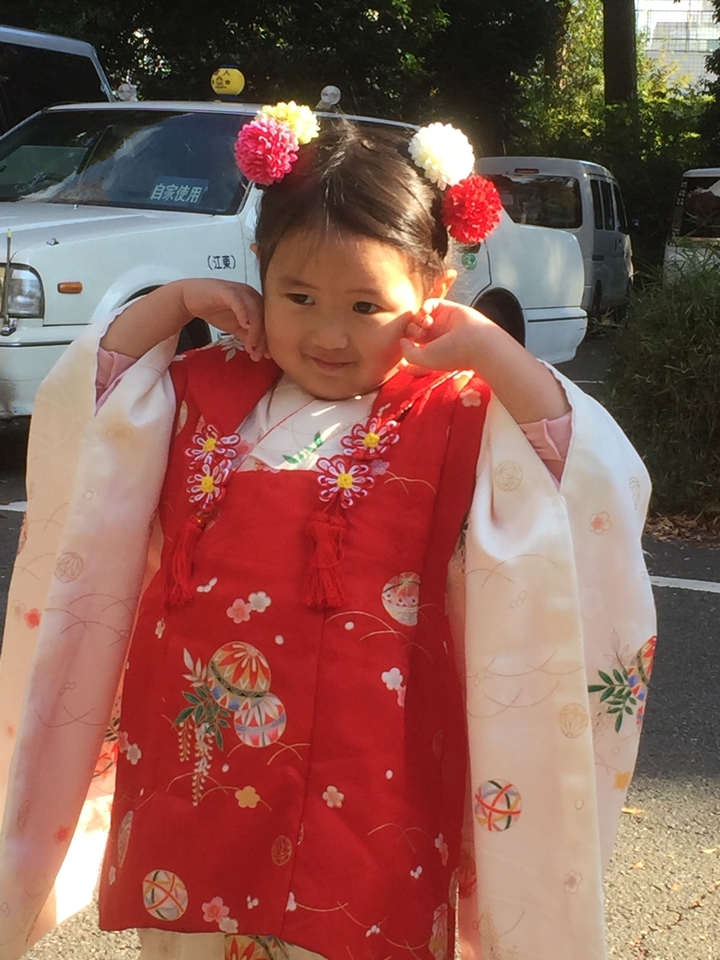 Enfant en vêtements traditionnels posant à l'extérieur.