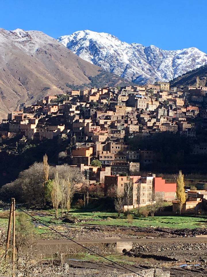 A densely packed hillside town with earthy-colored buildings.