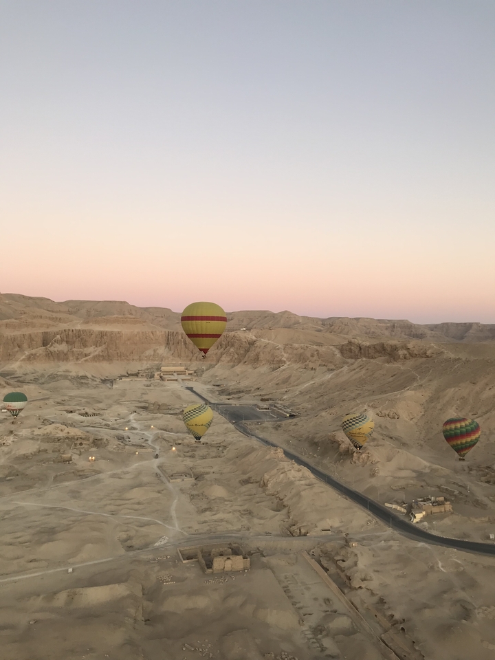 Montgolfières s'élevant au-dessus d'un paysage désertique.