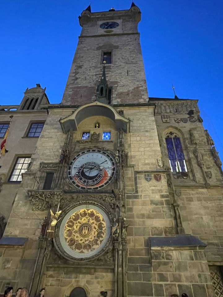 Horloge astronomique sur une tour historique dans un cadre urbain.