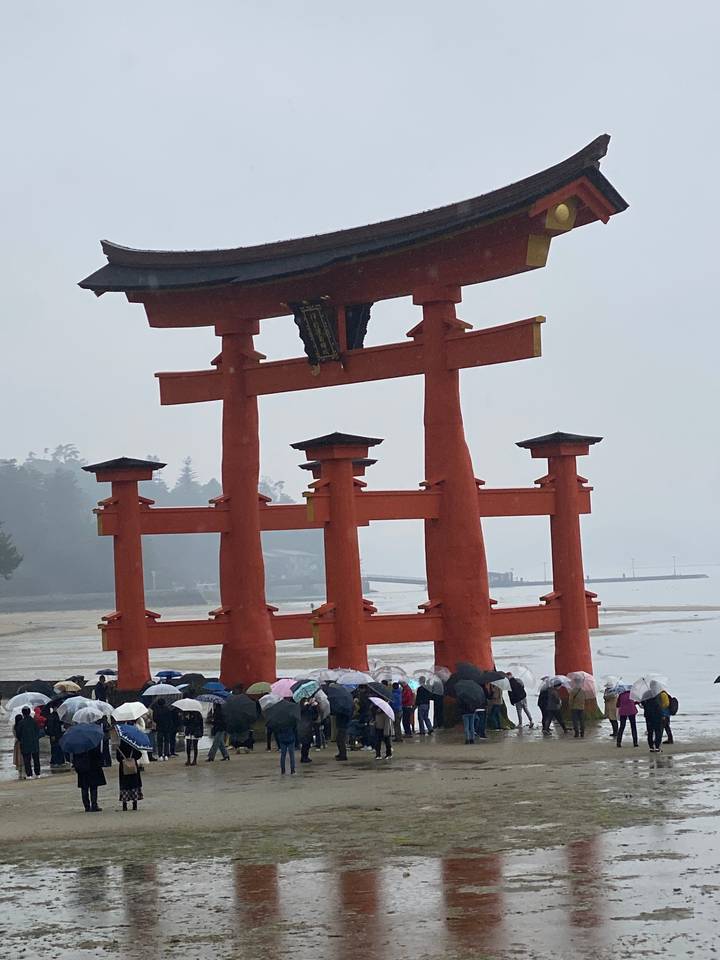 Porte torii avec des gens qui passent dessous.