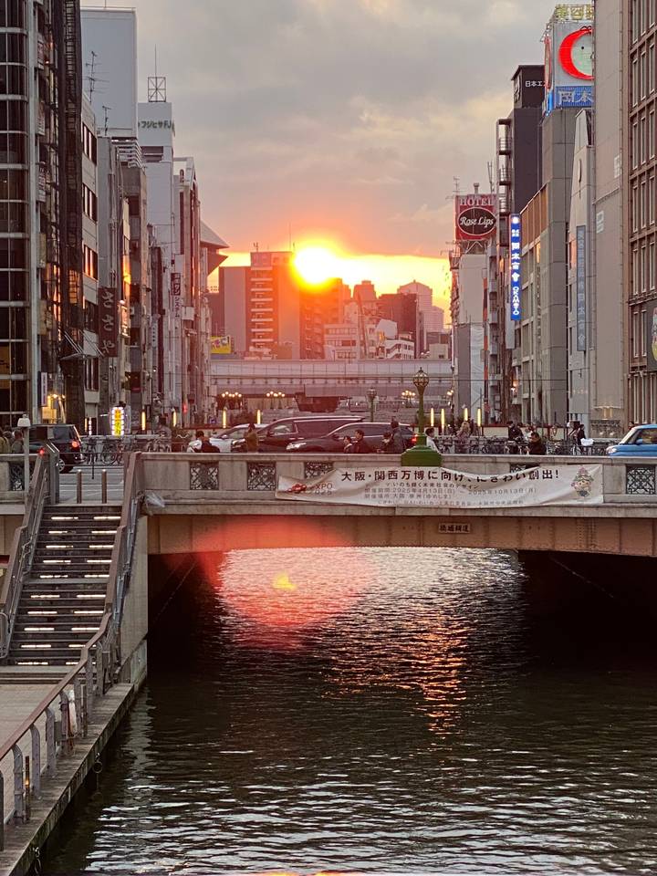 Coucher de soleil sur une ville traversée par une rivière.