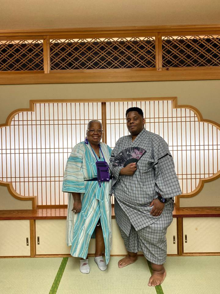 Deux personnes en tenue traditionnelle dans une pièce.