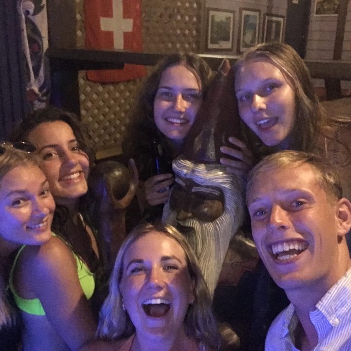 Selfie de groupe avec une statue dans un cadre faiblement éclairé