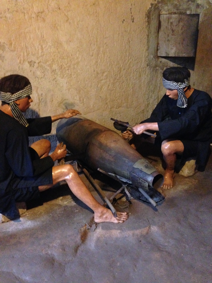 Deux personnages travaillant sur une réplique de grande bombe.