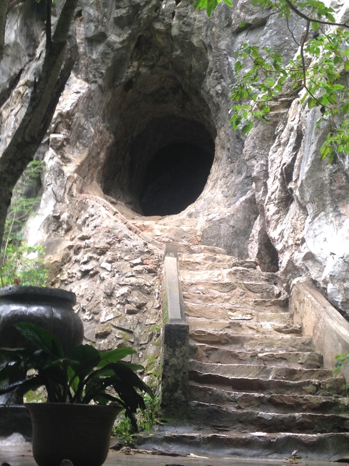 Des marches de pierre menant à une grotte.
