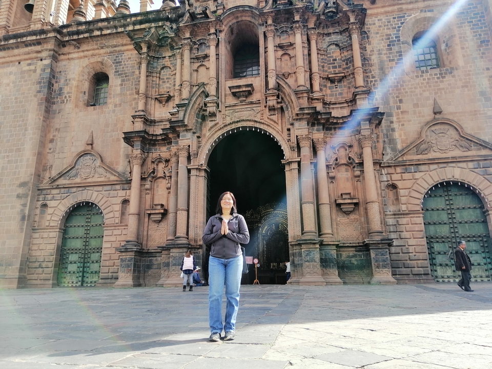 Personne debout devant l'entrée d'une cathédrale historique en pierre.
