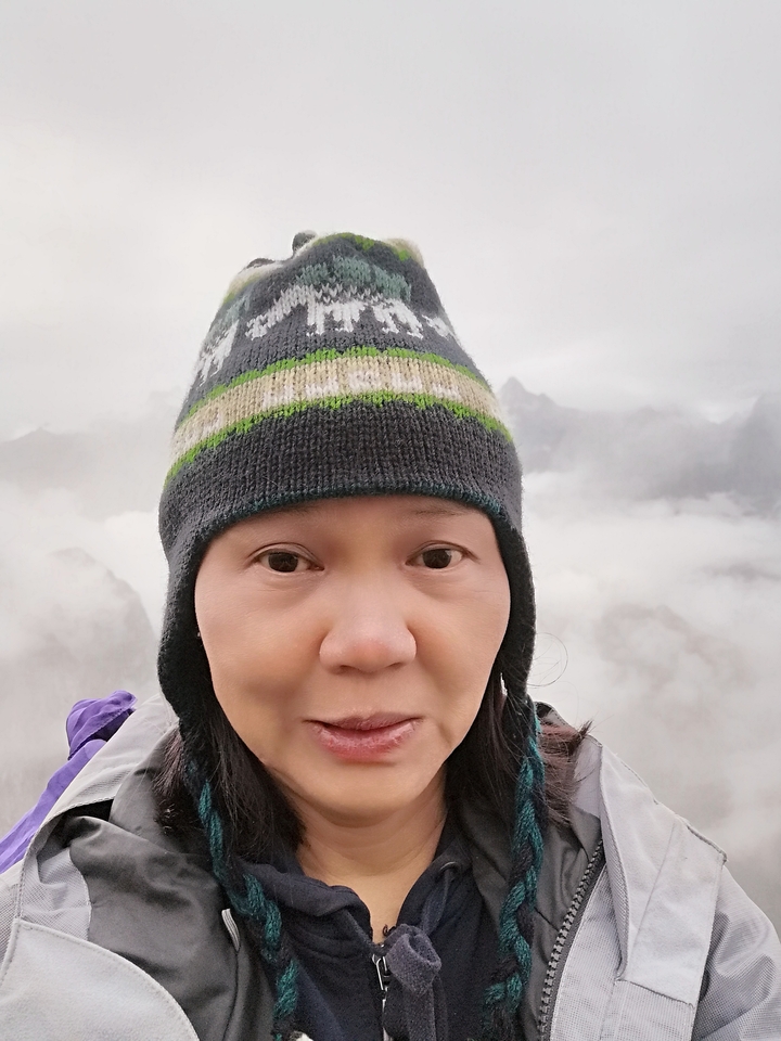 Portrait en gros plan d'une personne avec un arrière-plan montagneux brumeux.