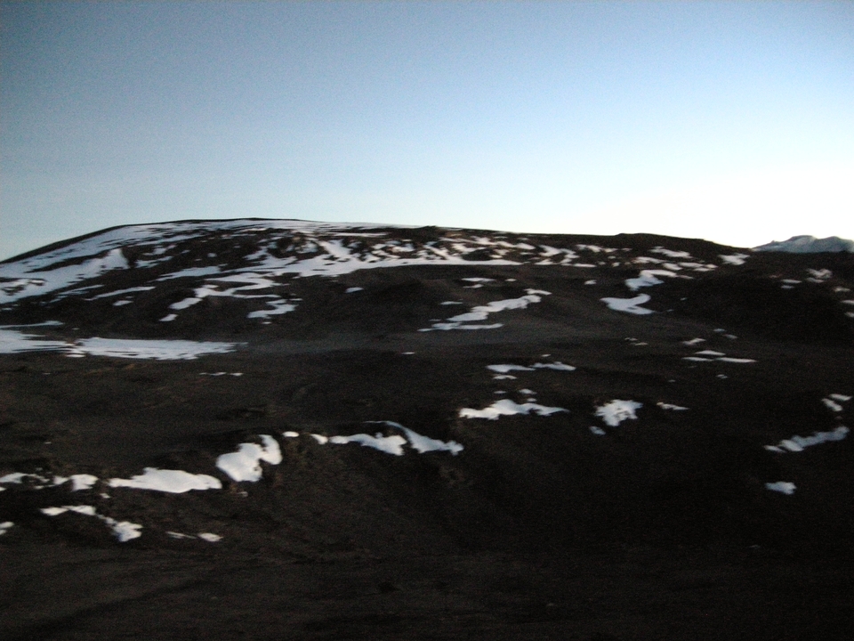 Terrain montagneux accidenté et enneigé avec des plaques de neige sur une montagne.