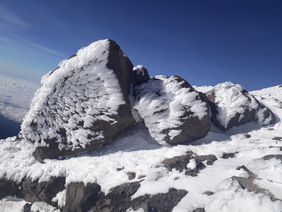 Formations rocheuses enneigées sous un ciel dégagé.