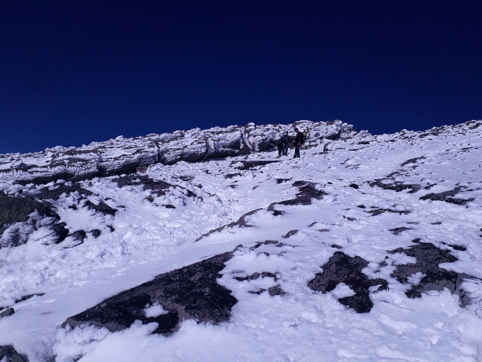 Randonneurs naviguant sur un sentier de montagne enneigé.