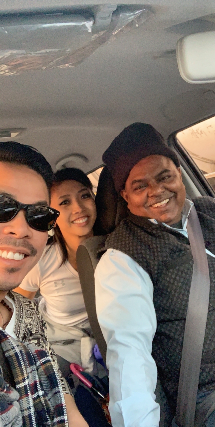 Selfie de trois personnes à l'intérieur d'un véhicule, souriantes.