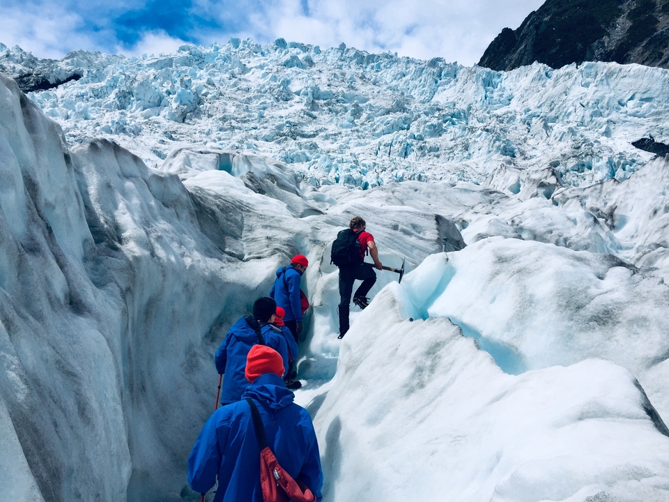 Groupe faisant de la randonnée à travers des crevasses glacées sur un glacier.