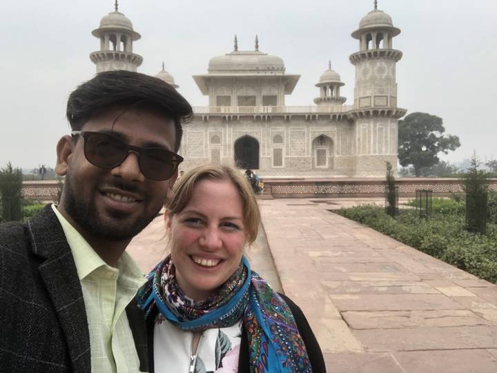 Two people taking a selfie in front of a historic building.