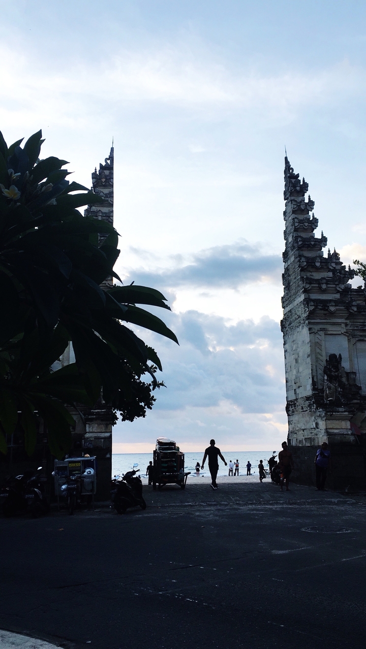 Vue partielle d'un temple avec ciel et feuillage.