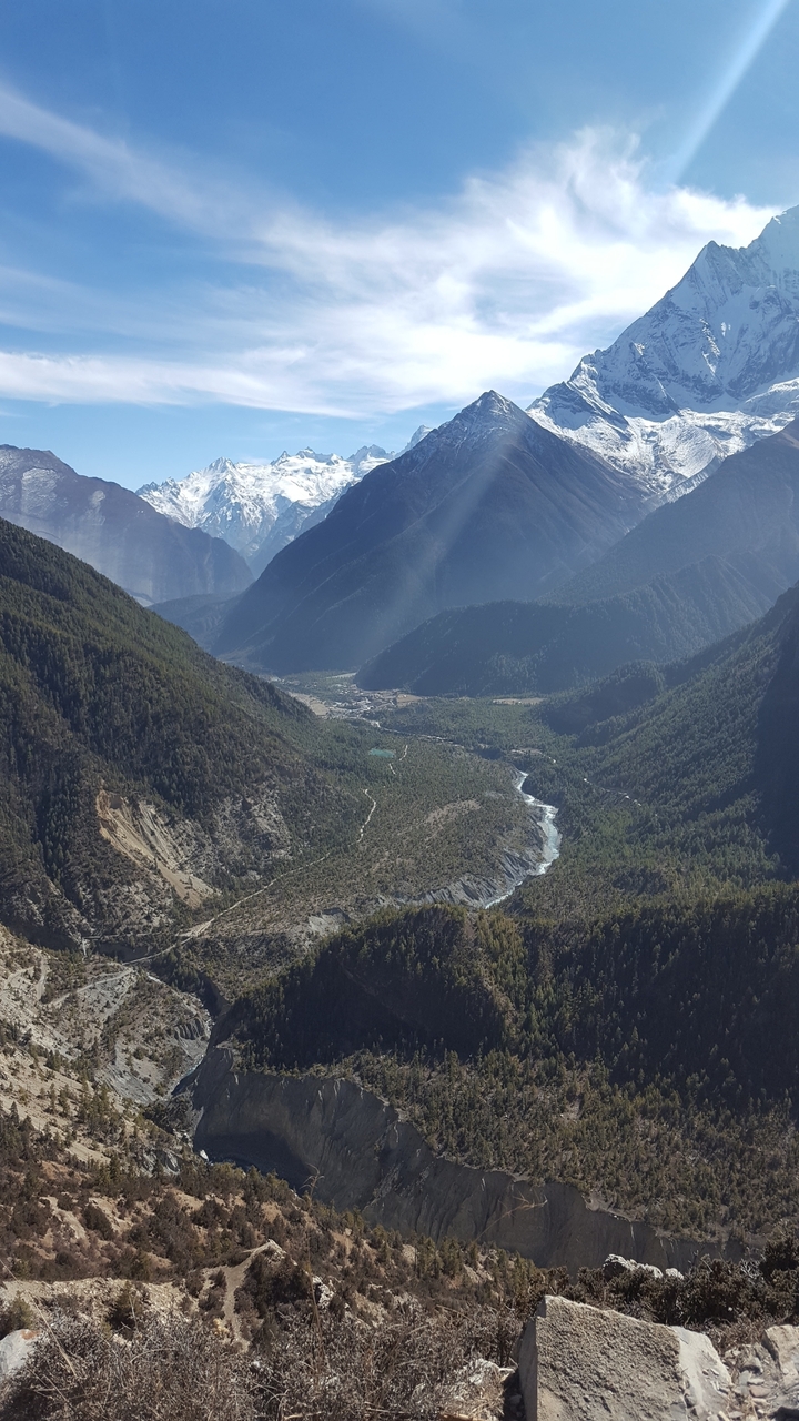 Vue aérienne d'une vallée avec une rivière et les montagnes environnantes.