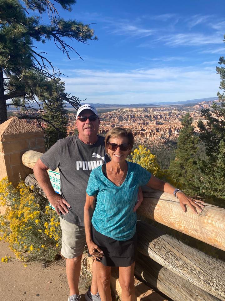Couple posant avec une vue panoramique de Bryce Canyon.
