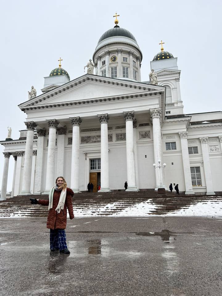 Personne debout devant une grande cathédrale blanche avec des colonnes.