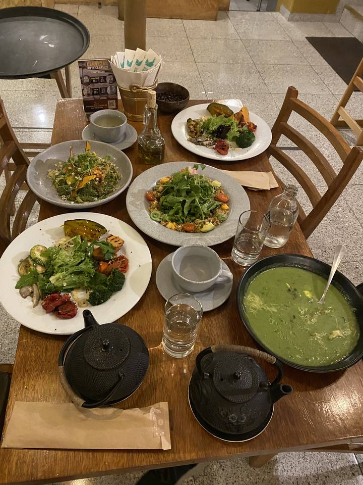 Table pleine de salades et soupes colorées.