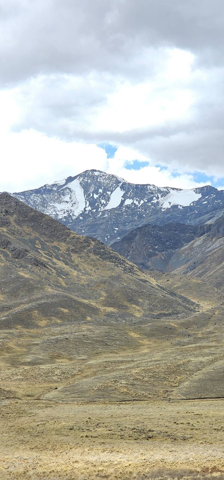 Une vue pittoresque d'un sommet de montagne enneigé sous un ciel nuageux.