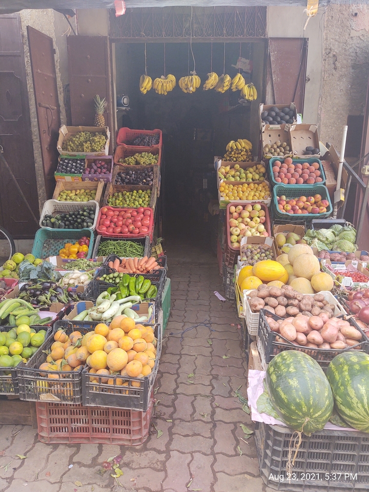 Variété colorée de fruits et légumes exposée dans un marché ouvert.
