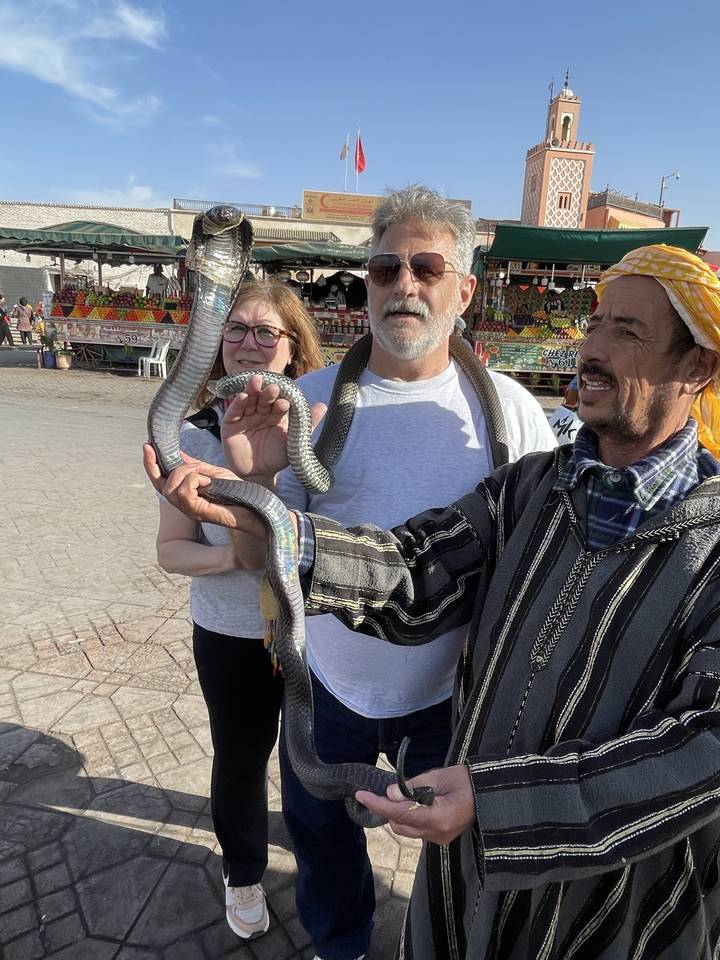 Des personnes tenant des serpents dans un environnement extérieur.