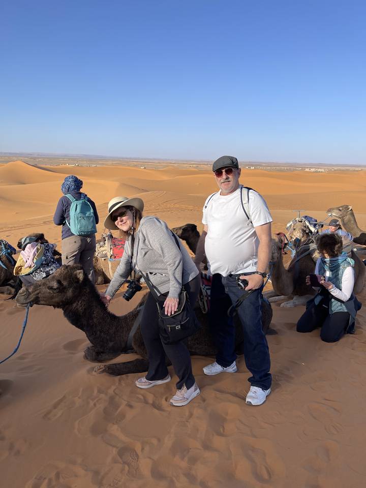 Groupe de personnes avec des chameaux sur le sable du désert.