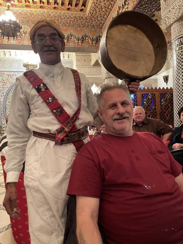Homme posant avec une personne déguisée dans un restaurant.