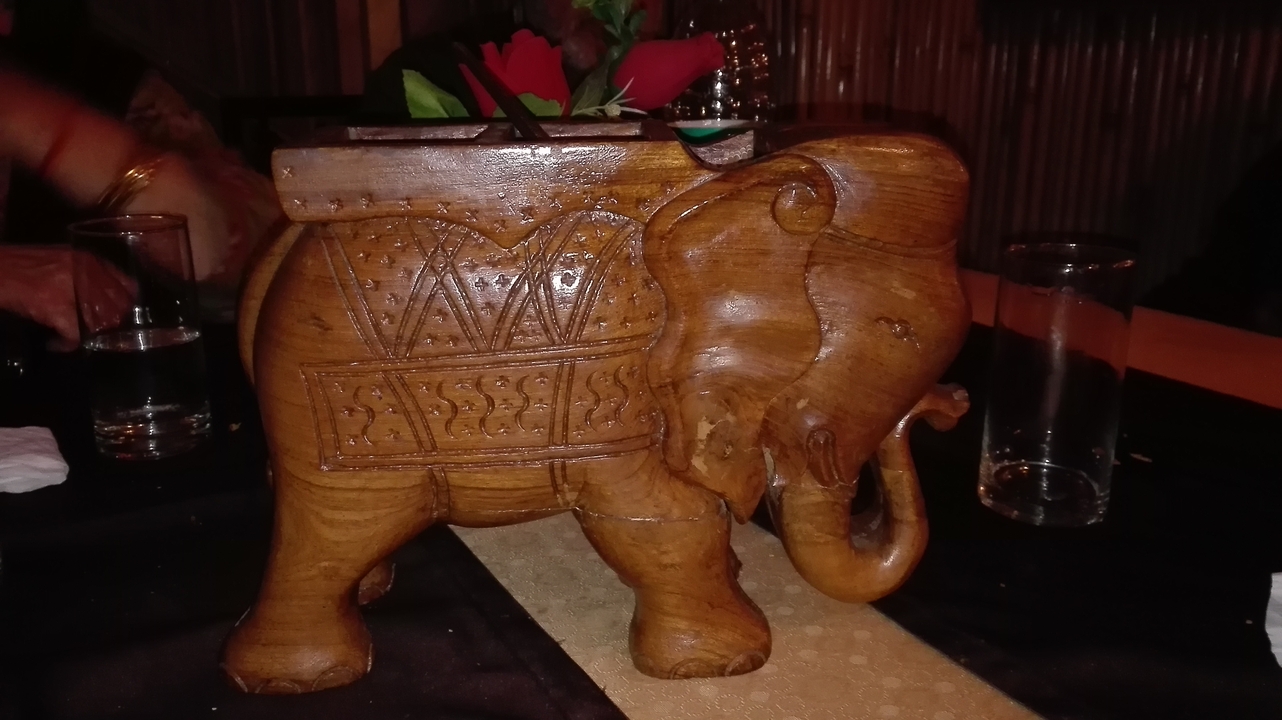Sculpture d'éléphant en bois sur une table.