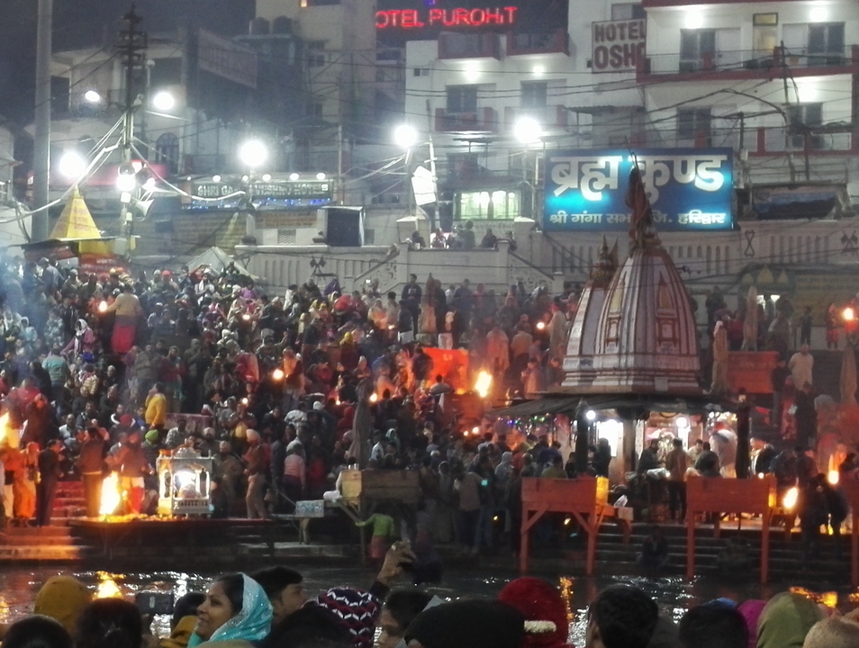 Ghat bondé avec des gens participant à des activités religieuses la nuit.