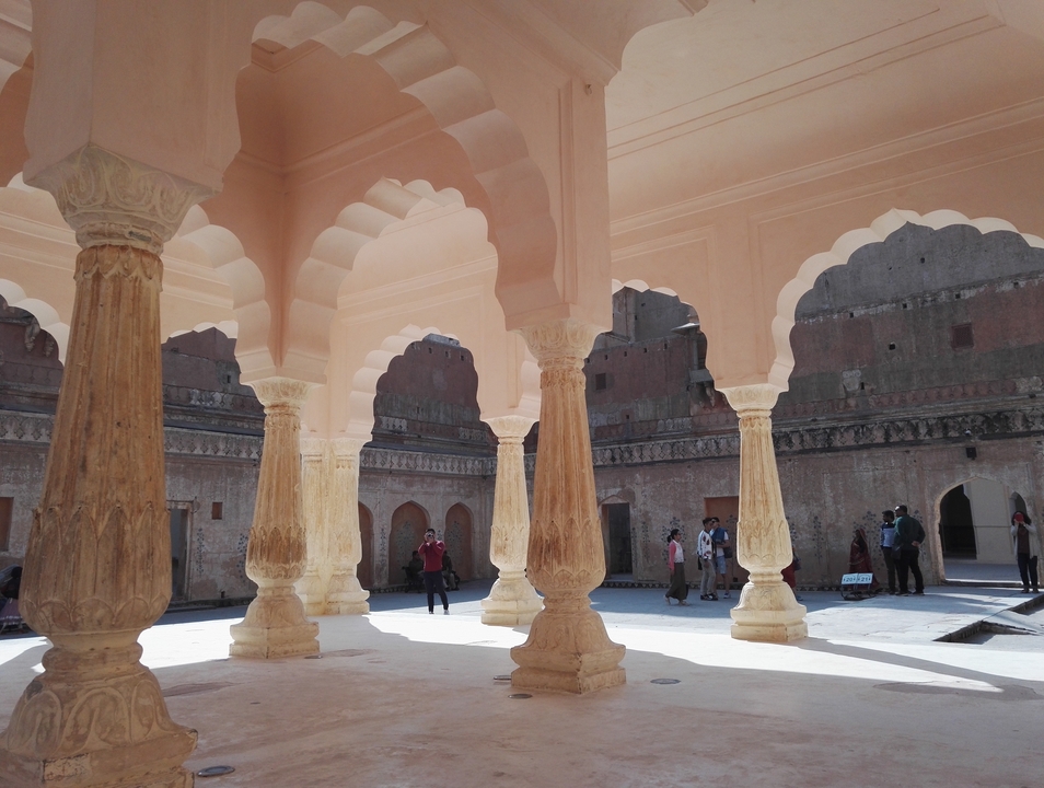 Cour palatiale avec arches et colonnes.