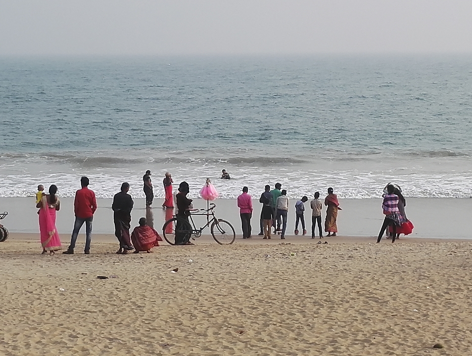 Des gens se sont rassemblés sur un rivage sablonneux face à l'océan.