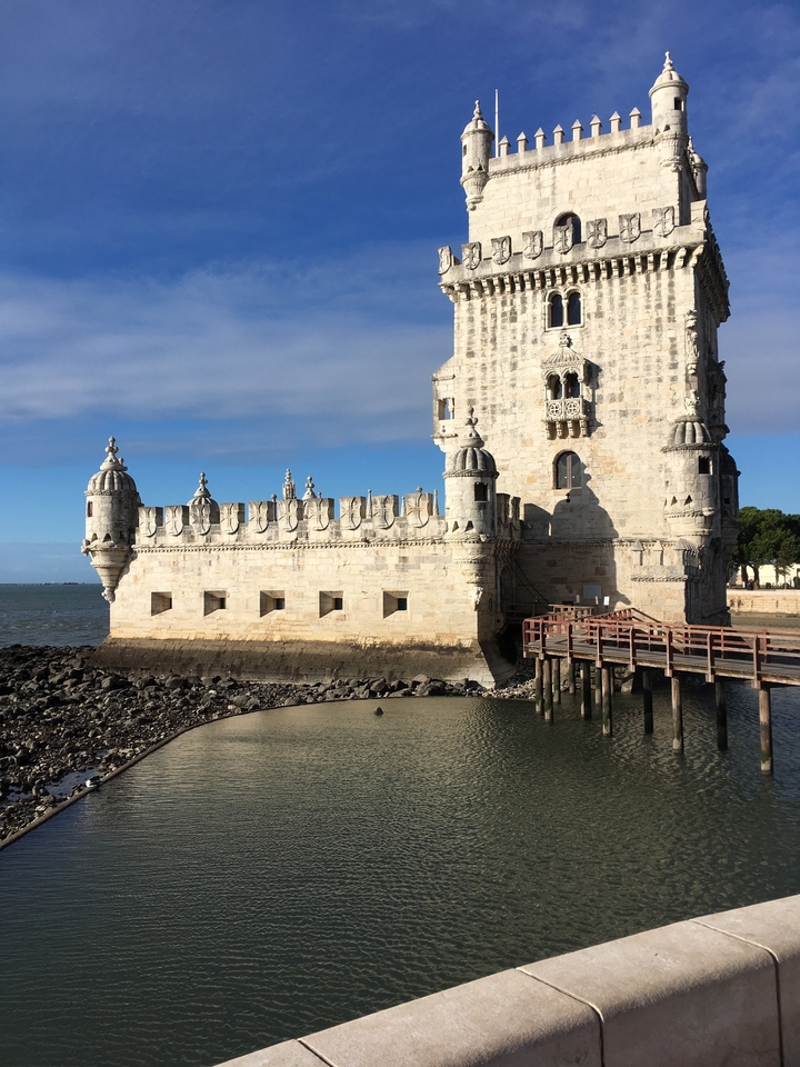 Stone fortification by the water with towers and detailed architecture.