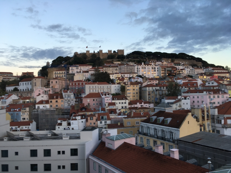 Colorful urban panorama with a historic castle on a hill.