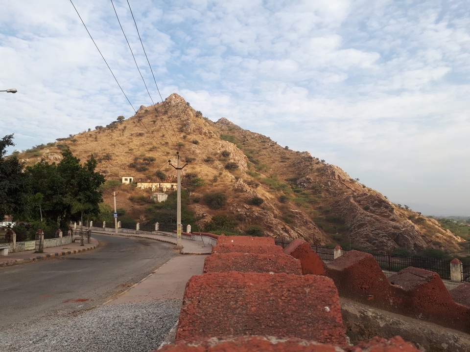 Colline avec végétation clairsemée à côté d'une route.
