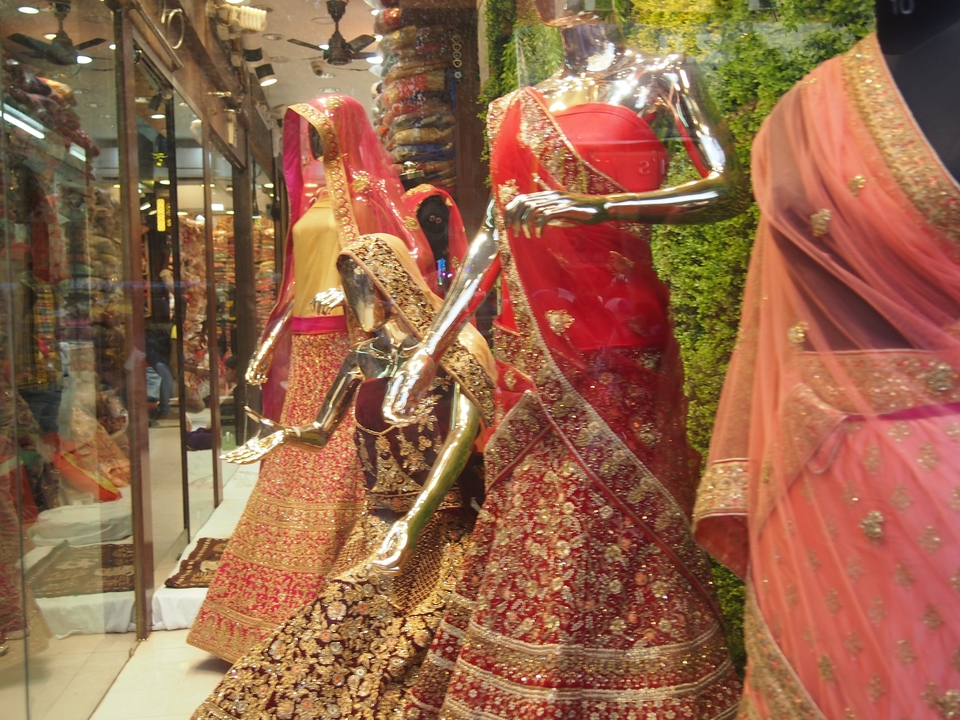 Vitrine de magasin présentant des robes indiennes traditionnelles.