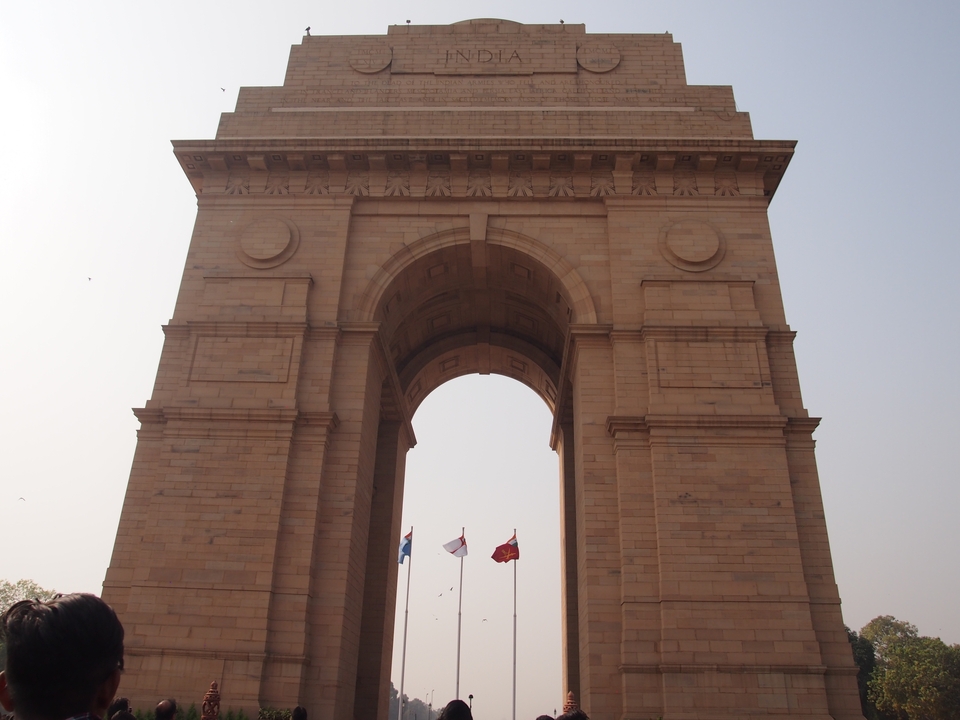 Grande porte en pierre avec des drapeaux qui flottent.