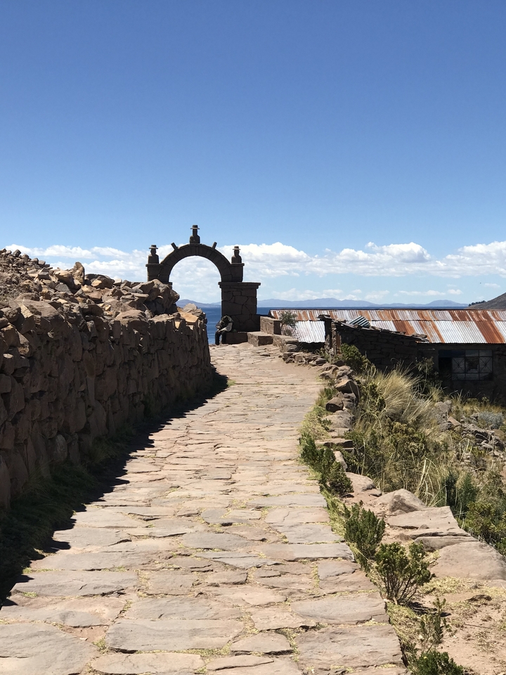 A stone archway on a path with scenic views.